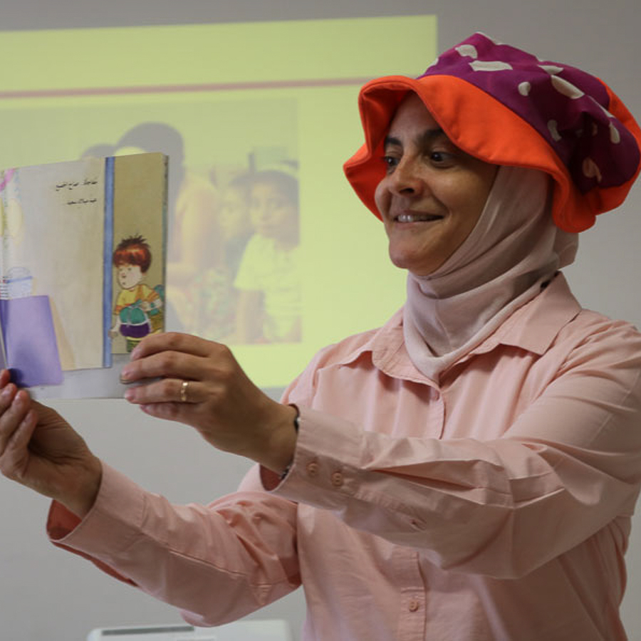 Rana holds up a picture book in a read-aloud session.